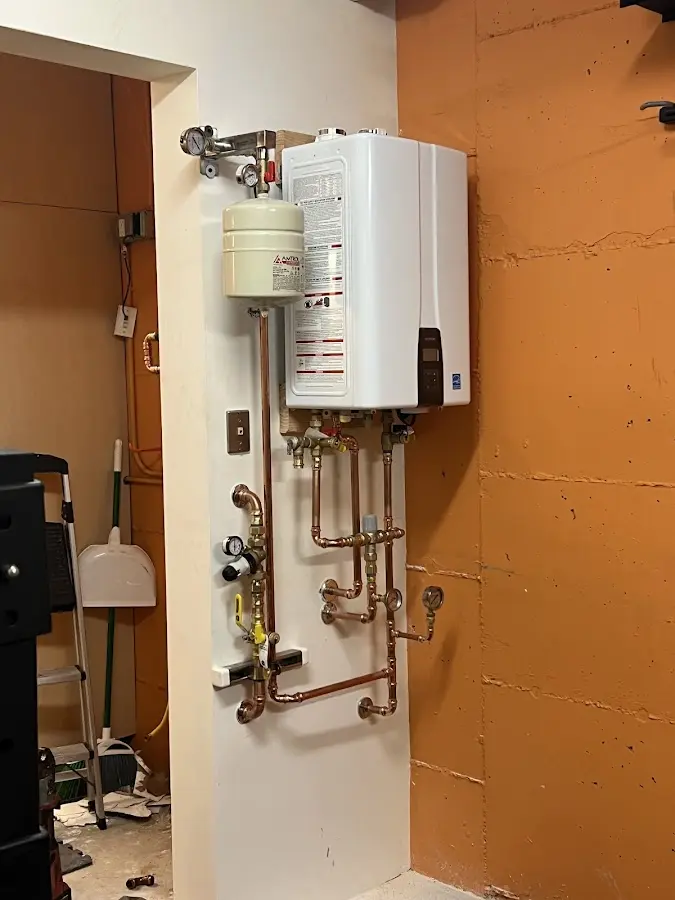 Plumbing technician inspecting water heater connections in Marine City